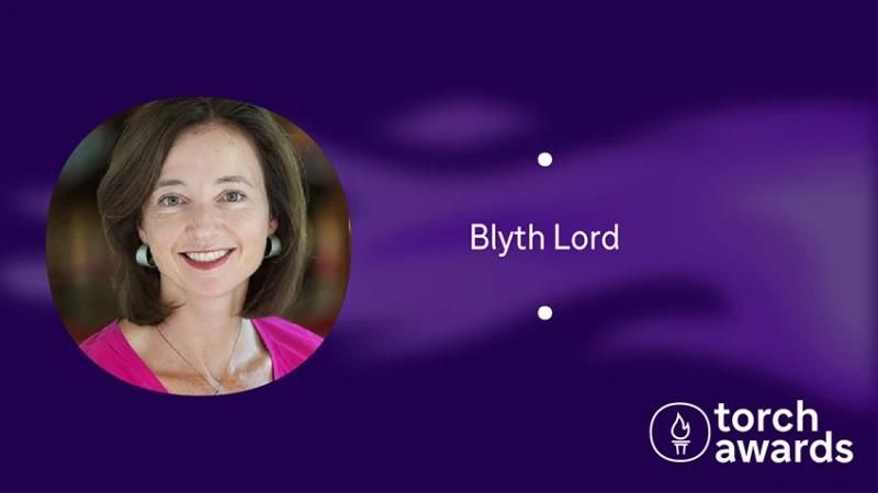 headshot of Blyth Lord on a variegated purple background and the torch awards logo in the lower right corner.
