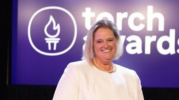 Annie Kennedy standing with the TORCH Awards logo in the background.