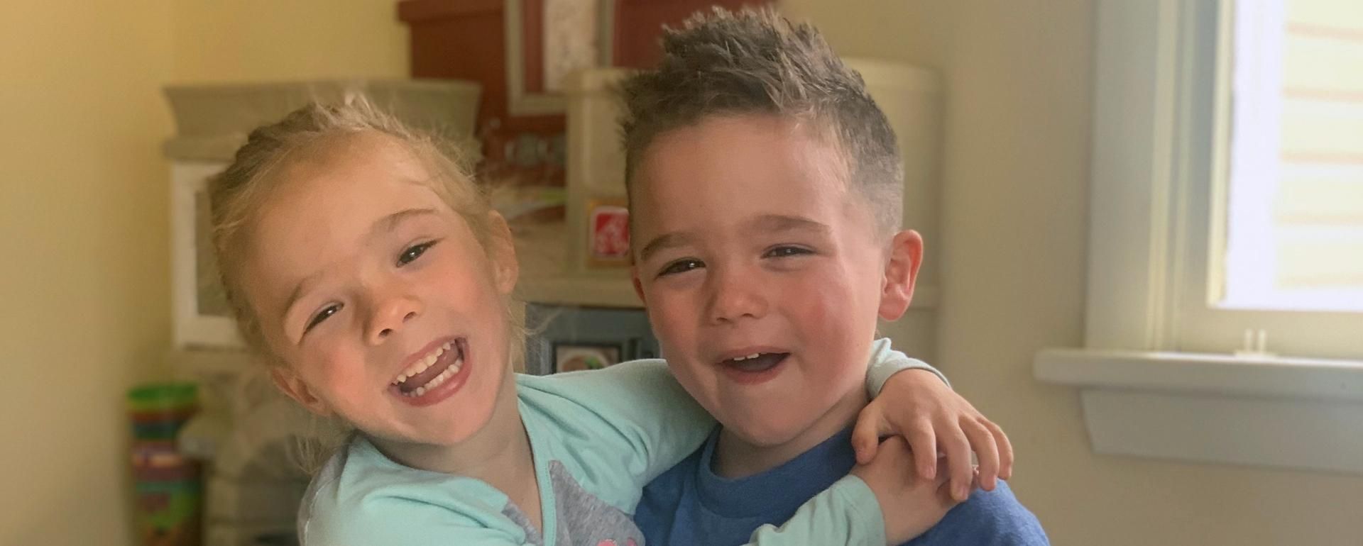 Ryder and Rylee smile at the camera while they hug each other.