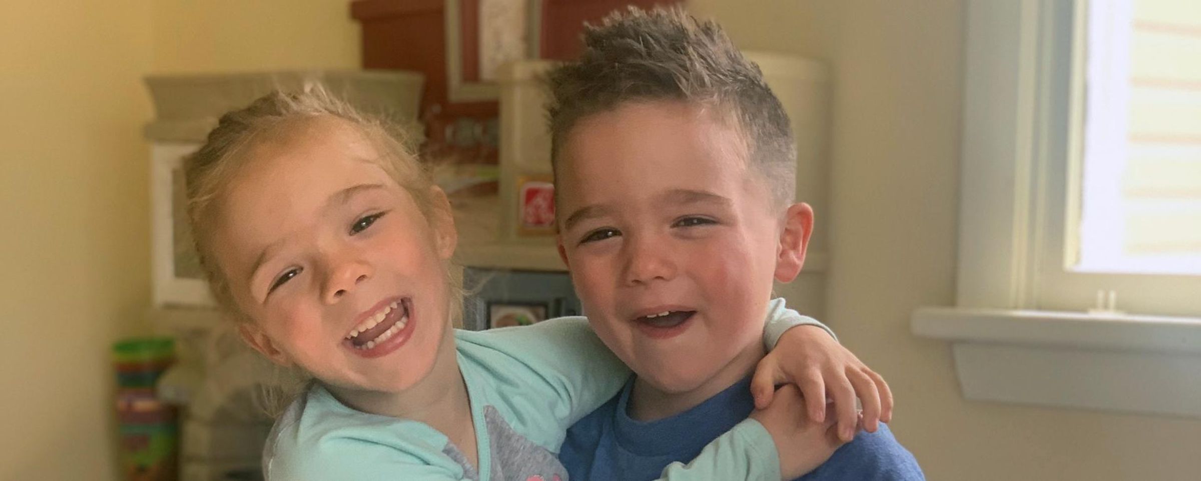 Ryder and Rylee smile at the camera while they hug each other.