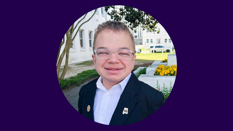 Zachary Thomas is shown wearing a dark blue blazer and a white shirt.