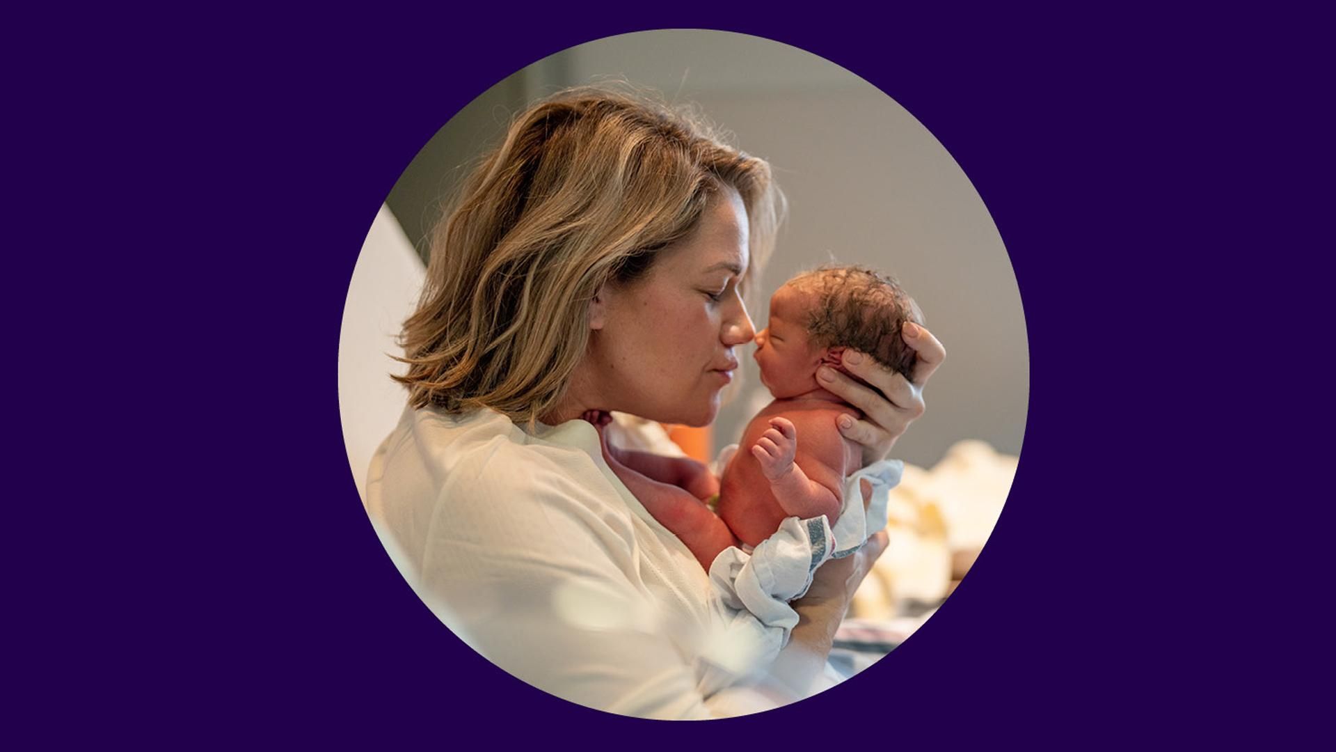 A woman holding a newborn child