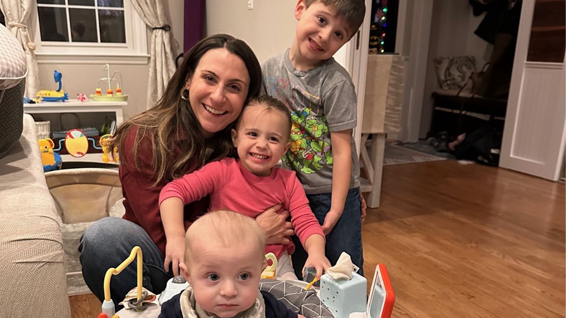 A mother smiles with her three children.