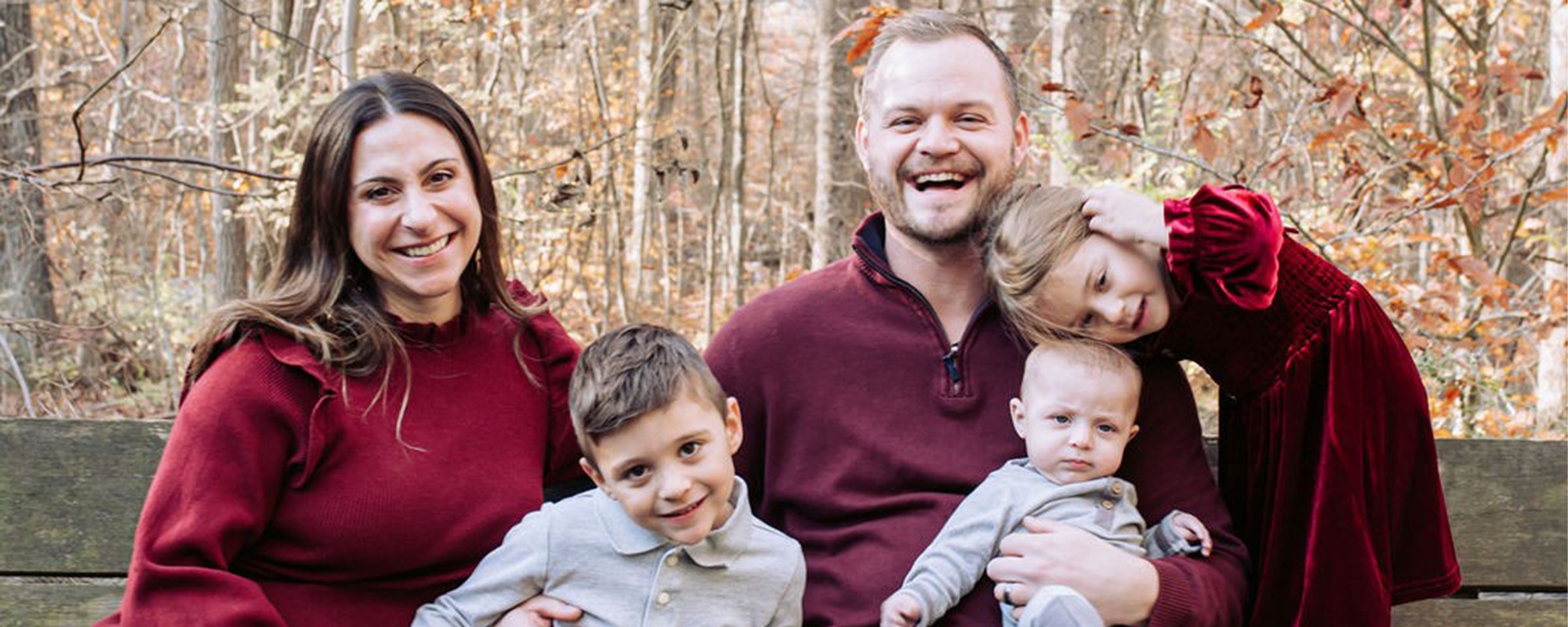 A mother and father smile with their three children.
