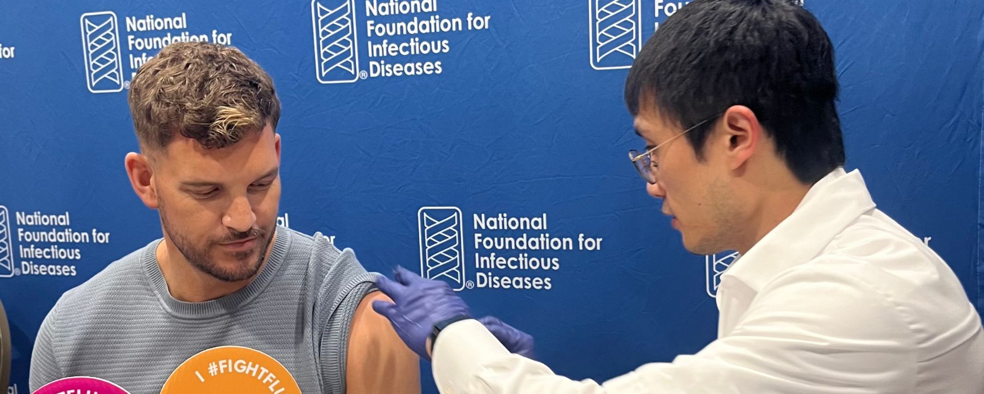 Sanofi employee receives his 2024 flu vaccine from a healthcare worker in a lab coat