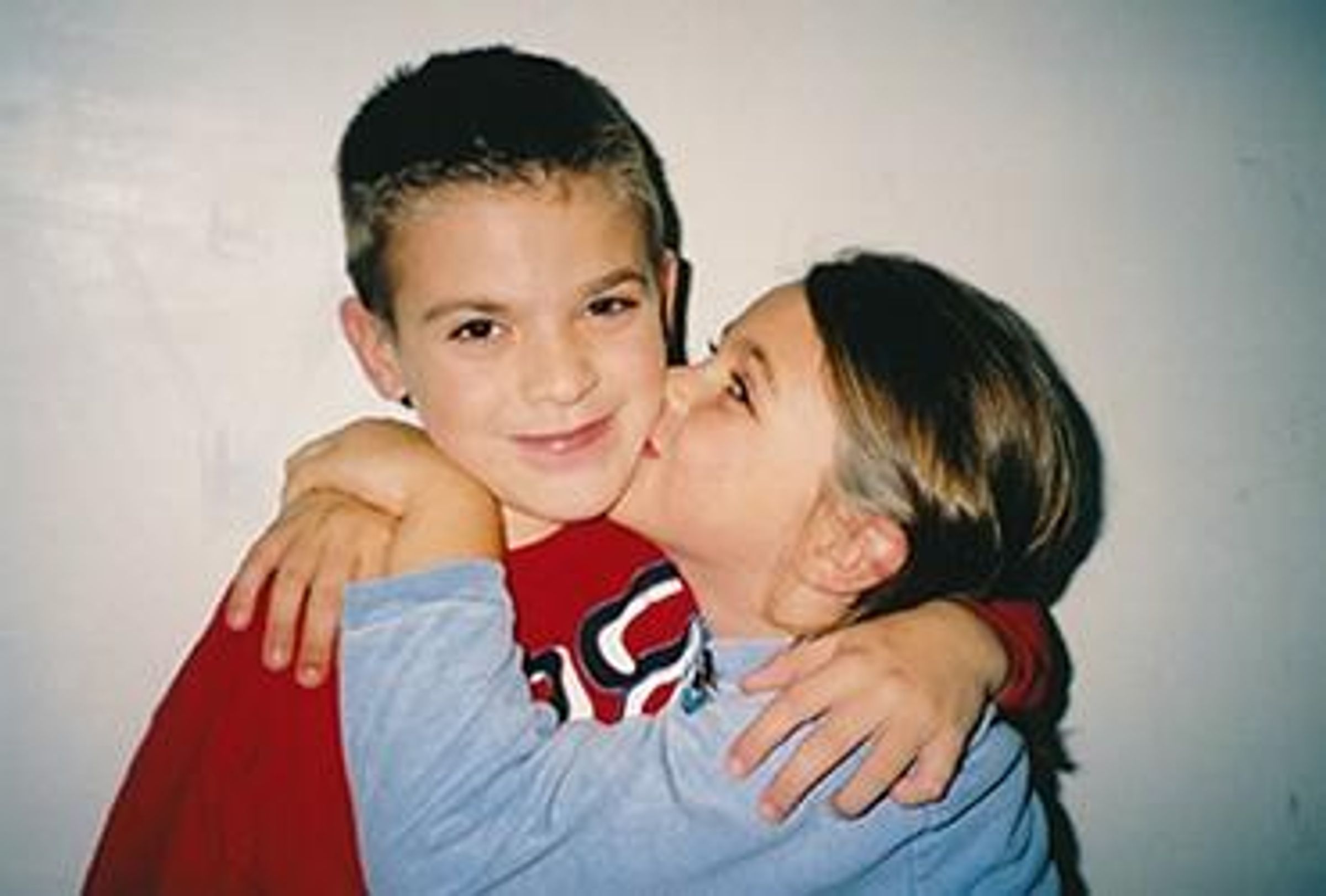 Taylor Smith kisses her brother Leland Smith on the cheek when they were children.