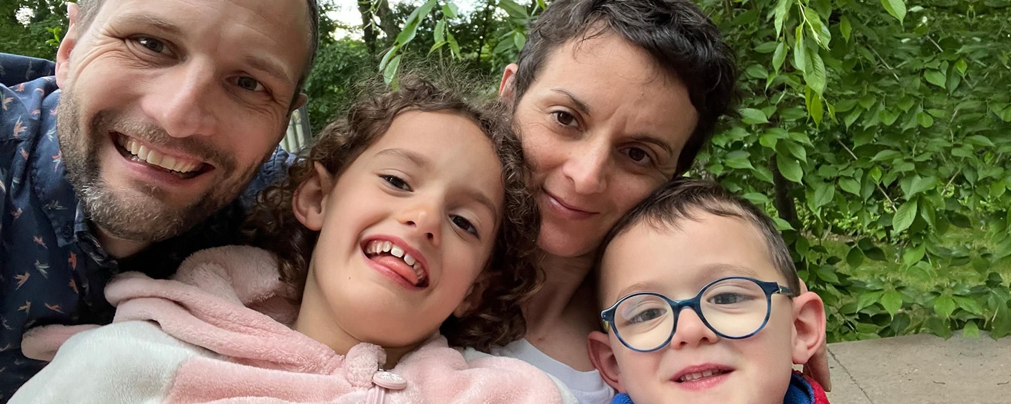 Thomas Grenier, his wife, daughter and son smile at the camera.