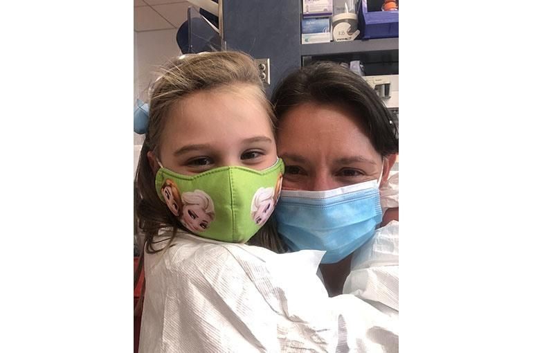 Kelly and her daughter hugging one another on a trip to one of Sanofi’s research and development labs.