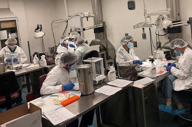 Kelly and her Pompe teammates wearing personal protective gear at a lab bench inside one of Sanofi’s research and development labs.
