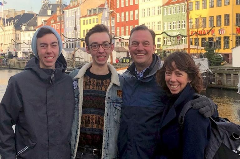 Robin Johnson stands with her husband and two sons against the backdrop of Copenhagen, Denmark