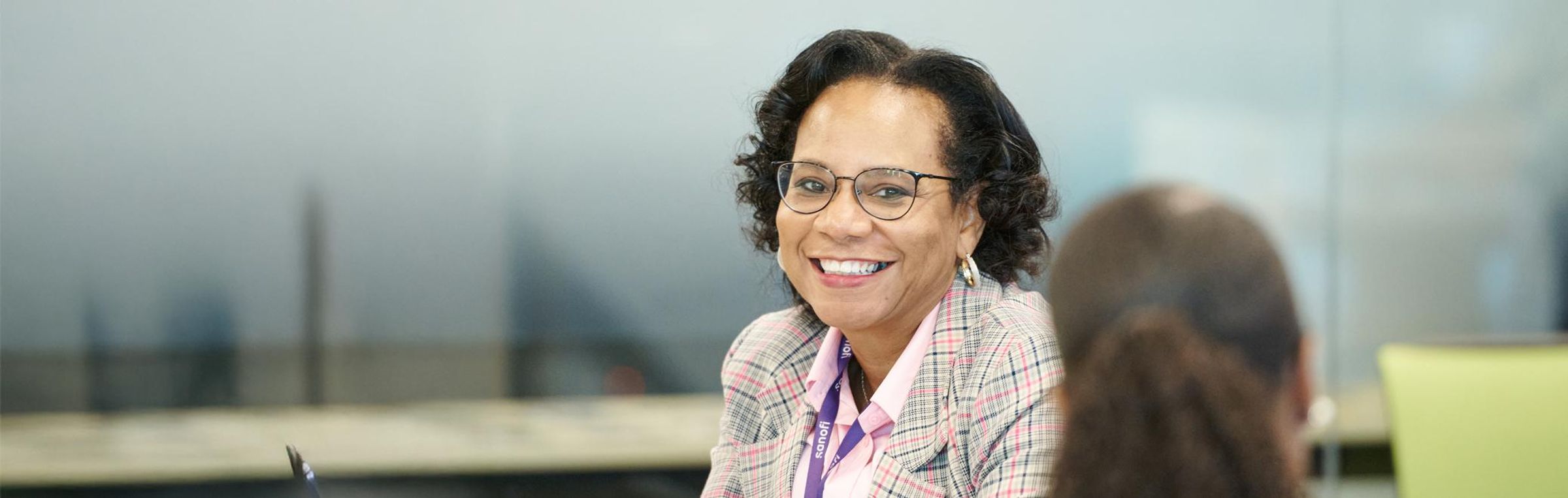 An African American woman smiles at her co-worker.