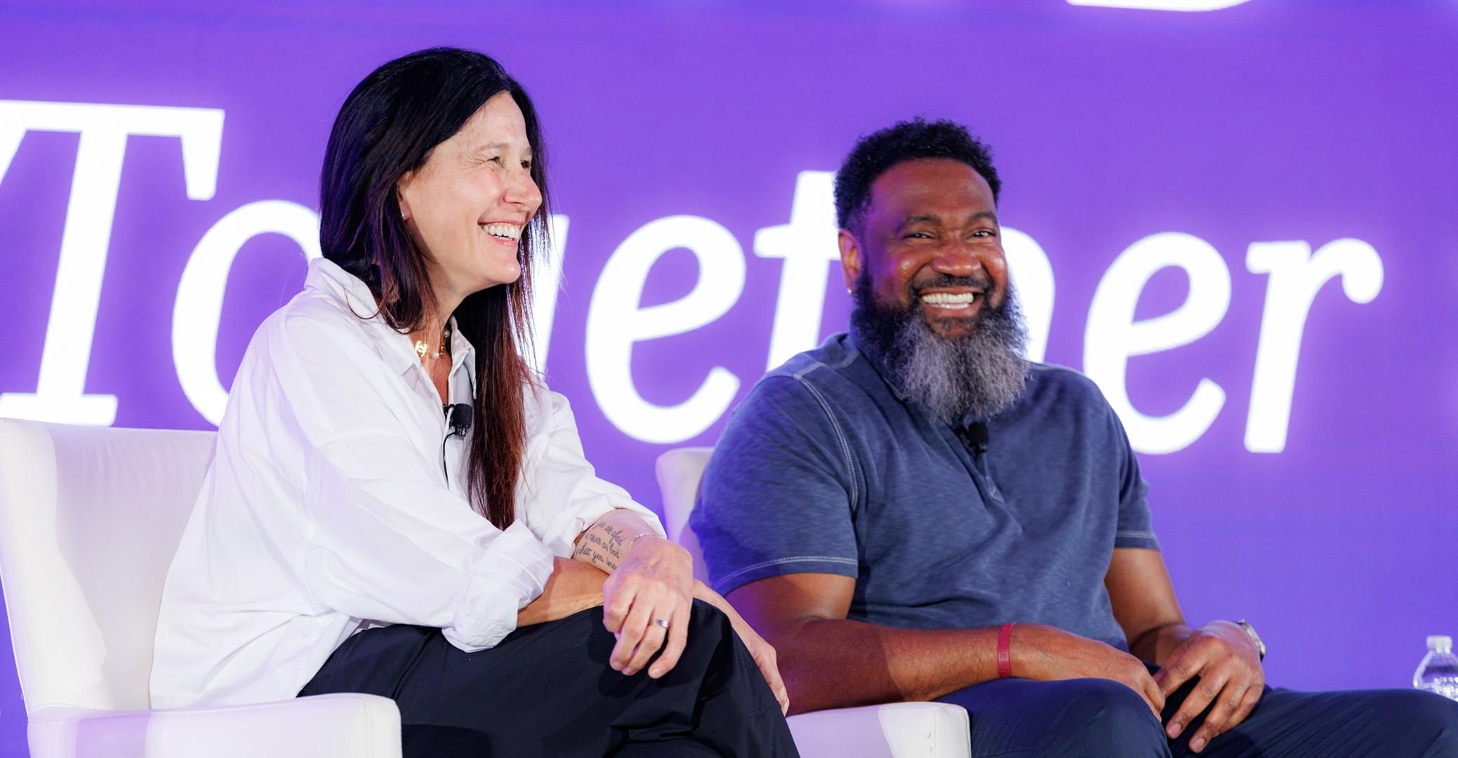 Thomas, living with multiple myeloma, sits next to his doctor, Dr. Cristina Gasparetto, both smiling at the audience