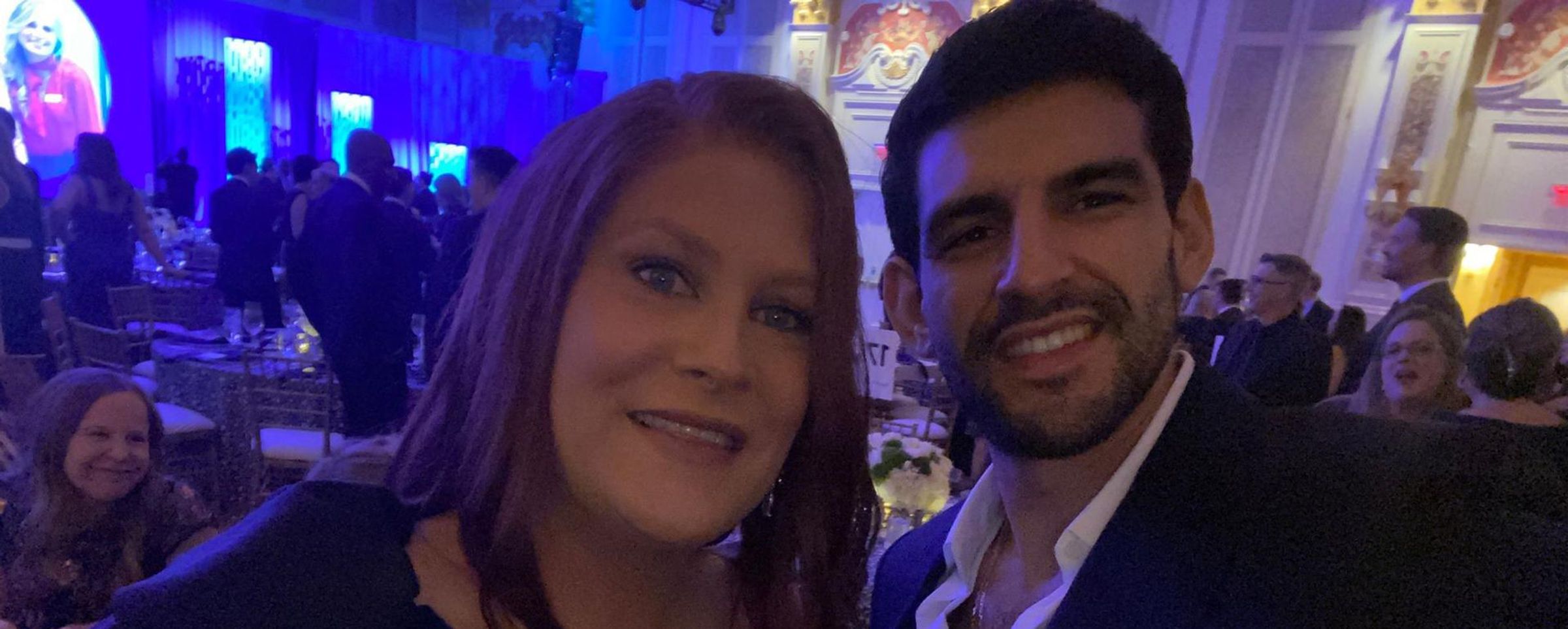 Keira Hobbs and her male friend smile at the camera at a gala event.