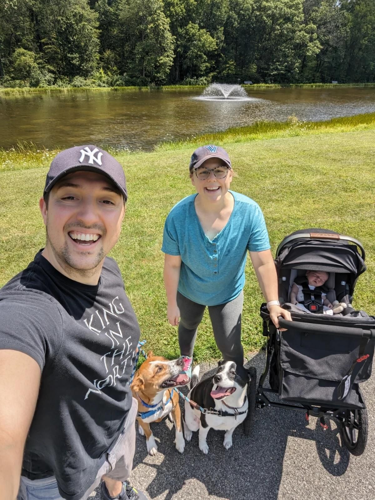 Jon Florio, his wife Meg, their daugther in a stroller, and two dogs near a lake while out for a walk.