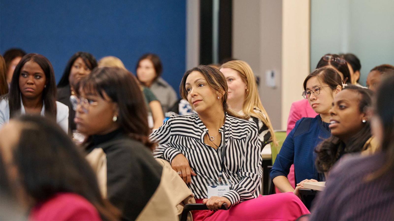 Group of women gathered in a conference room, engaged in conversation.